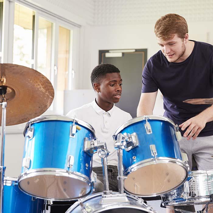 Boy having drumming lesson