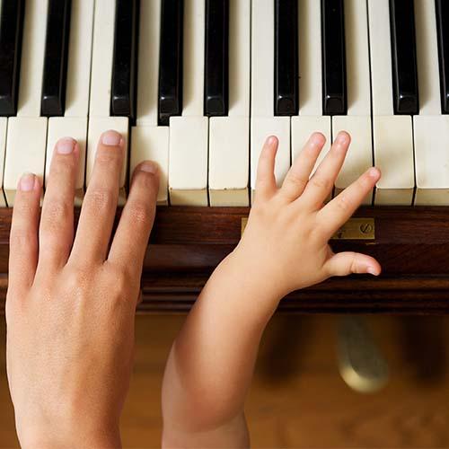 child learning to play piano